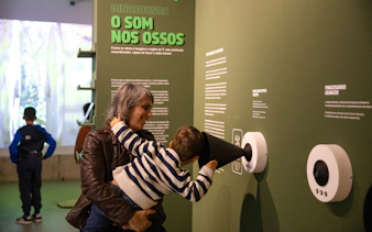 Tourists interacting with sound exhibit at Dino Experience Porto.