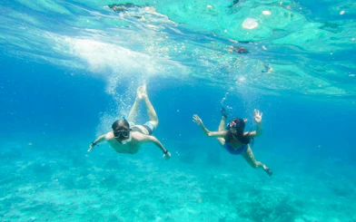 Snorkelers exploring clear waters on Heraklion catamaran cruise.