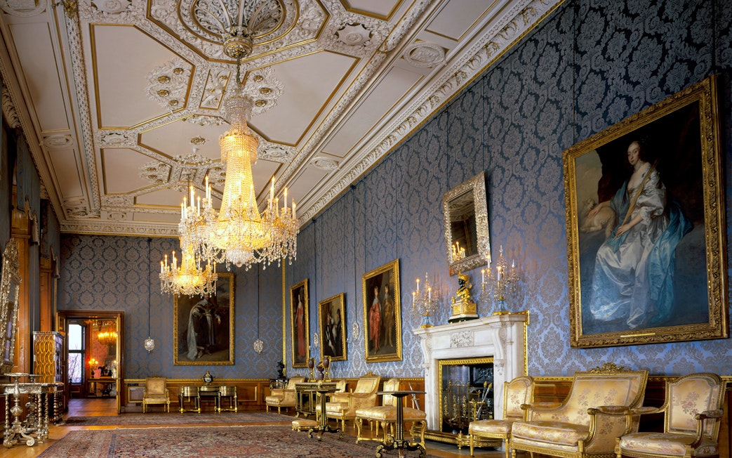 Windsor Castle interior with ornate chandeliers and historic paintings.