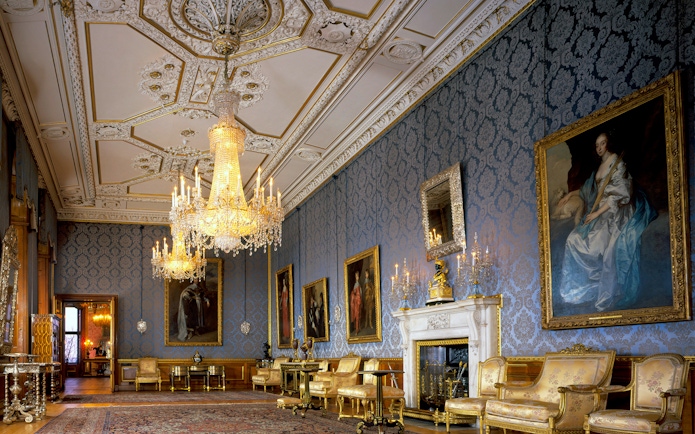 Windsor Castle interior with ornate chandeliers and historic paintings.