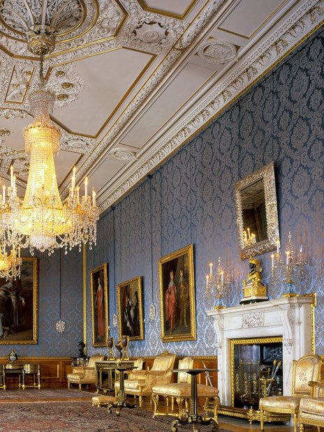 Windsor Castle interior with ornate chandeliers and historic paintings.