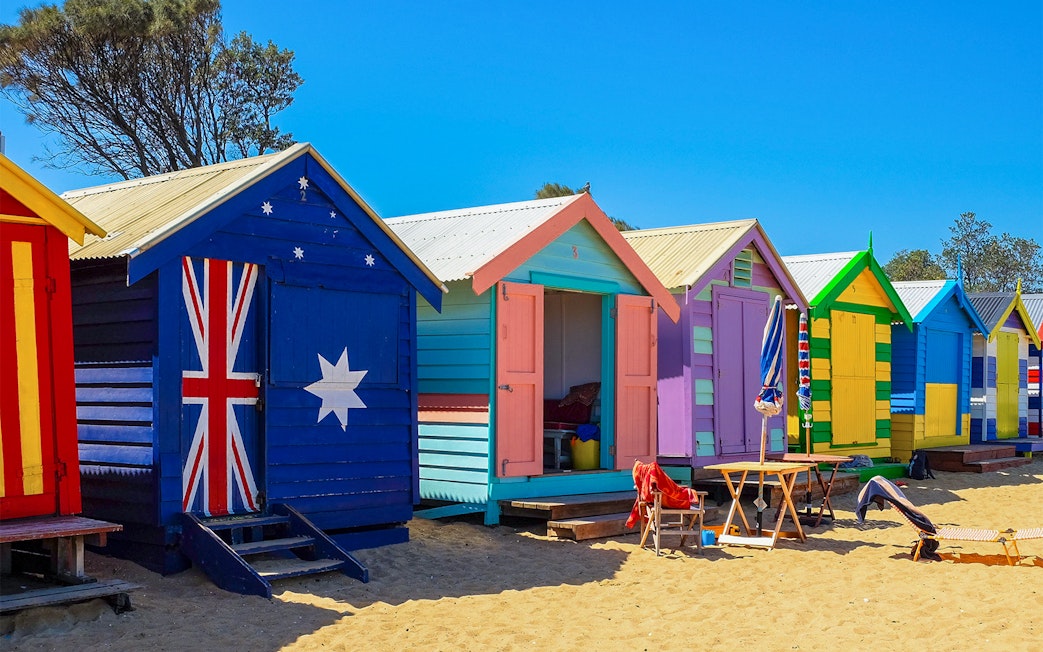 Colorful Brighton Beach Boxes lined up on sandy beach, Melbourne, Australia.