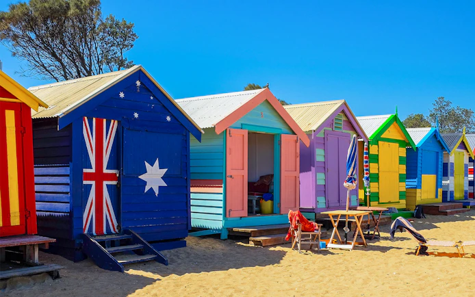 Colorful Brighton Beach Boxes lined up on sandy beach, Melbourne, Australia.