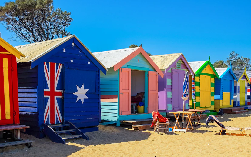 Colorful Brighton Beach Boxes lined up on sandy beach, Melbourne, Australia.