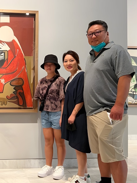 Tourist group with guide at Picasso Museum viewing artwork in Barcelona.