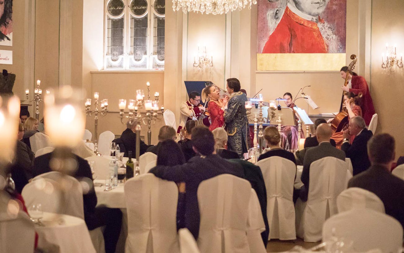 Mozart concert with performers in period costumes at a candlelit dinner in Salzburg.