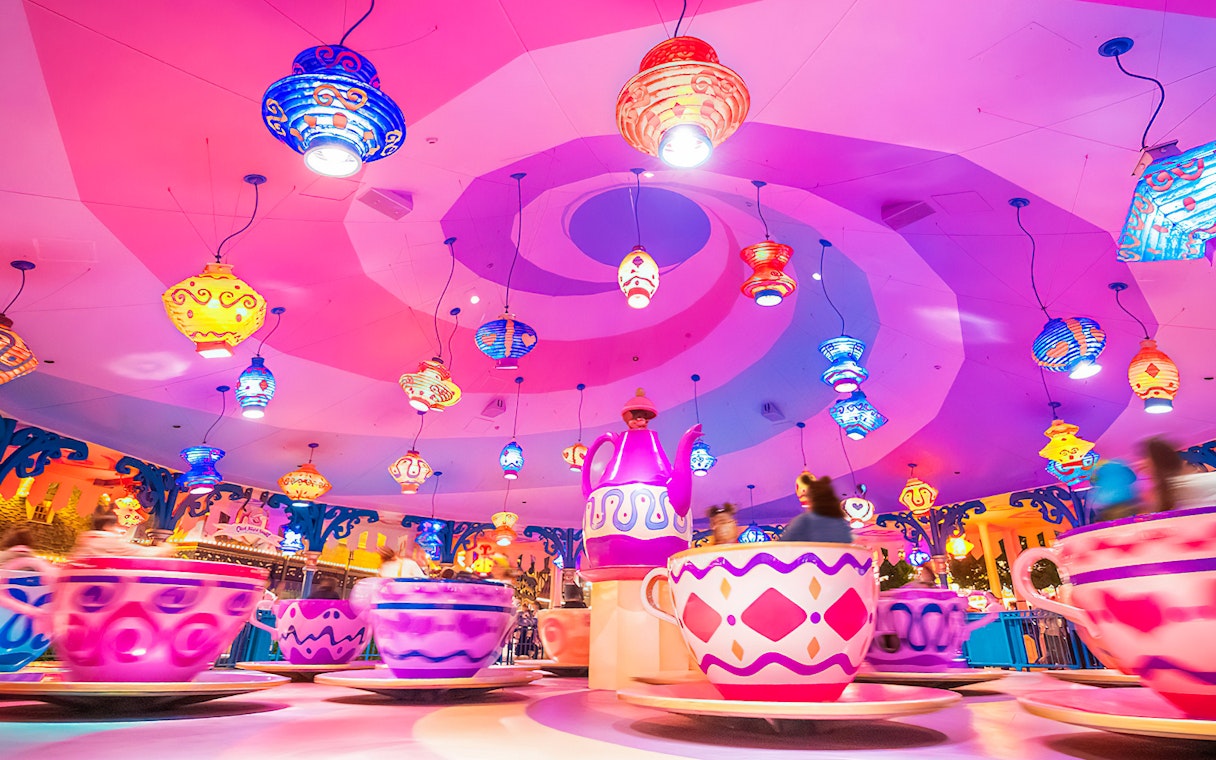 Colorful teacup ride at Tokyo Disneyland with vibrant hanging lanterns.