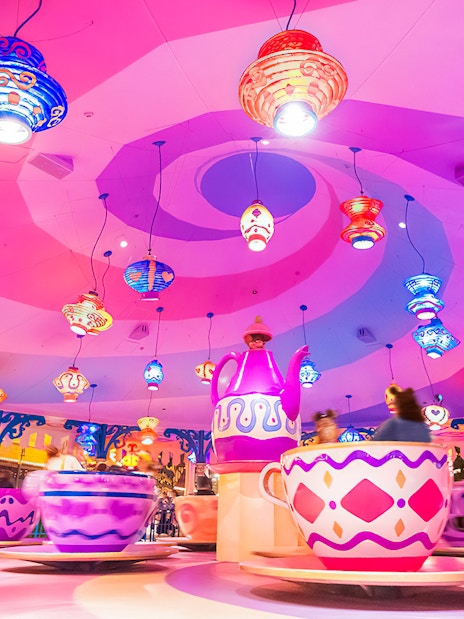 Colorful teacup ride at Tokyo Disneyland with vibrant hanging lanterns.