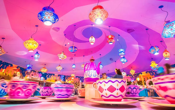 Colorful teacup ride at Tokyo Disneyland with vibrant hanging lanterns.