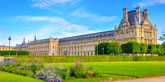 Louvre Museum with gardens and flowers in Paris.