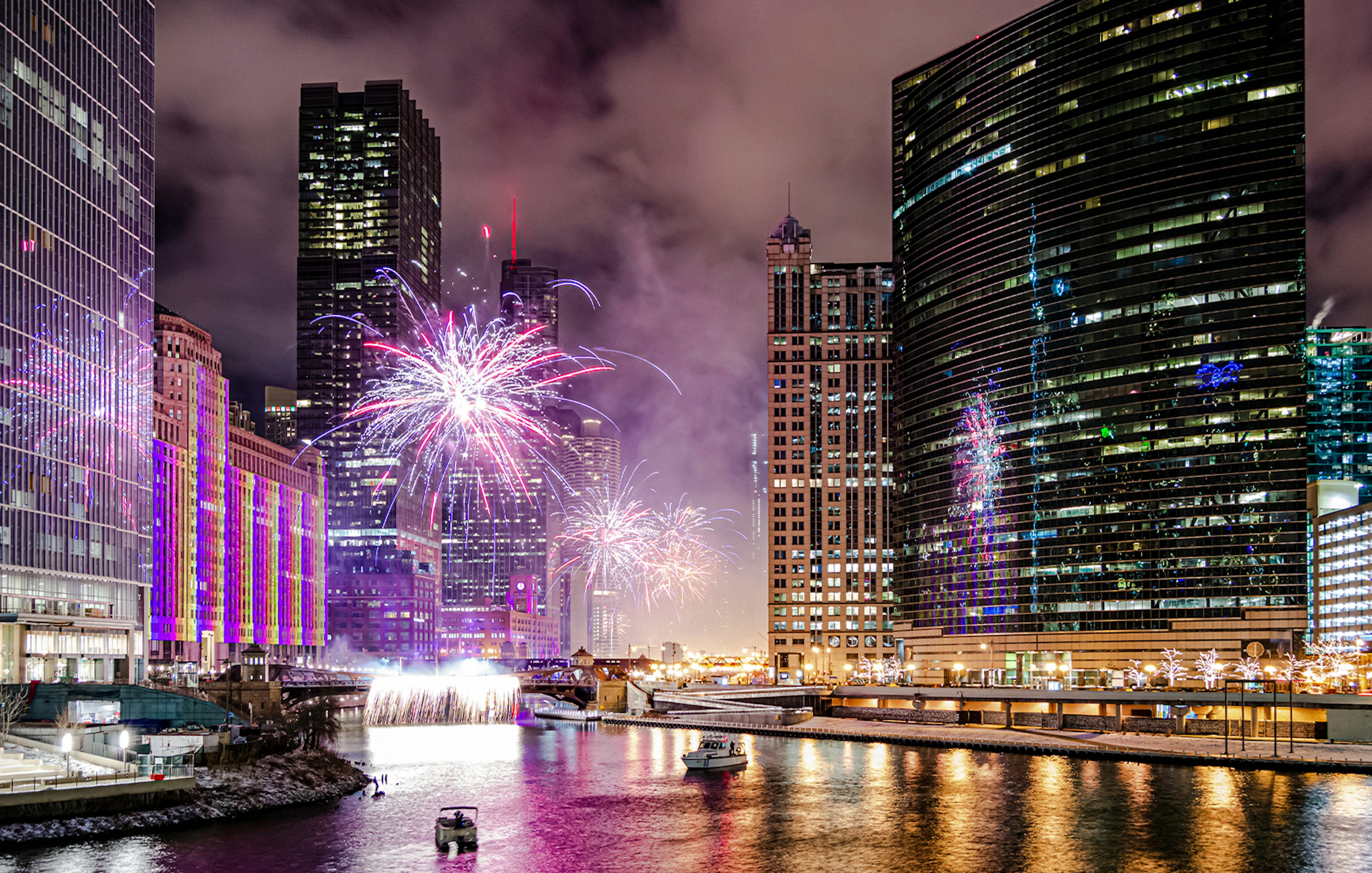 Fireworks over Chicago River with boats during dinner cruise.