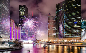 Fireworks over Chicago River with boats during dinner cruise.