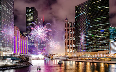 Fireworks over Chicago River with boats during dinner cruise.
