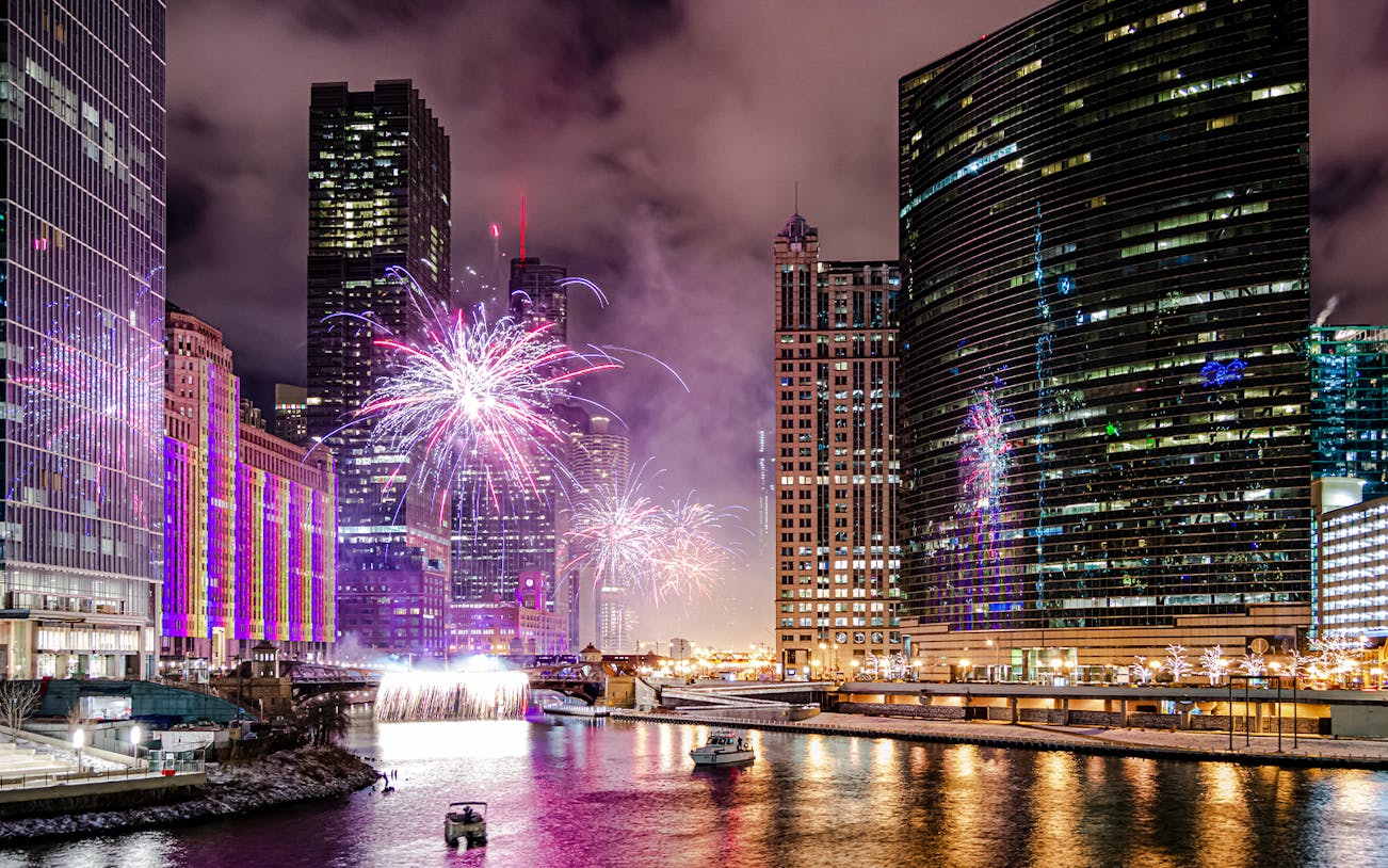 Fireworks over Chicago River with boats during dinner cruise.