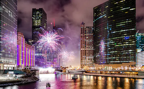 Fireworks over Chicago River with boats during dinner cruise.