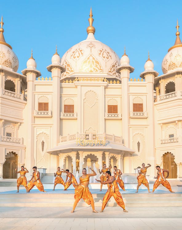 Dancers performing in front of ornate building at Bollywood Park Dubai, Dubai Parks and Resorts.