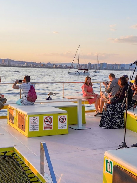 Musician performing on a Barcelona catamaran cruise at sunset.