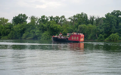 Boomerang Pirate Ship on river with partygoers, surrounded by trees, Washington DC.