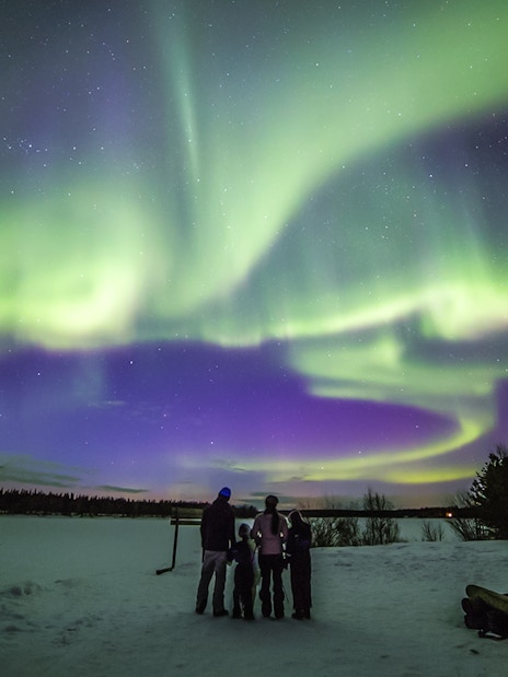Family watching Northern Lights in Levi, Finland.