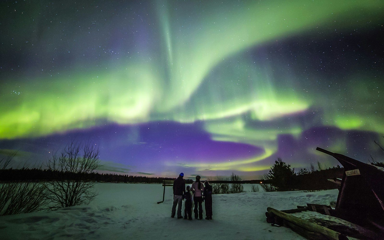 Family watching Northern Lights in Levi, Finland.