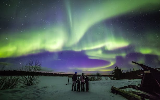 Family watching Northern Lights in Levi, Finland.