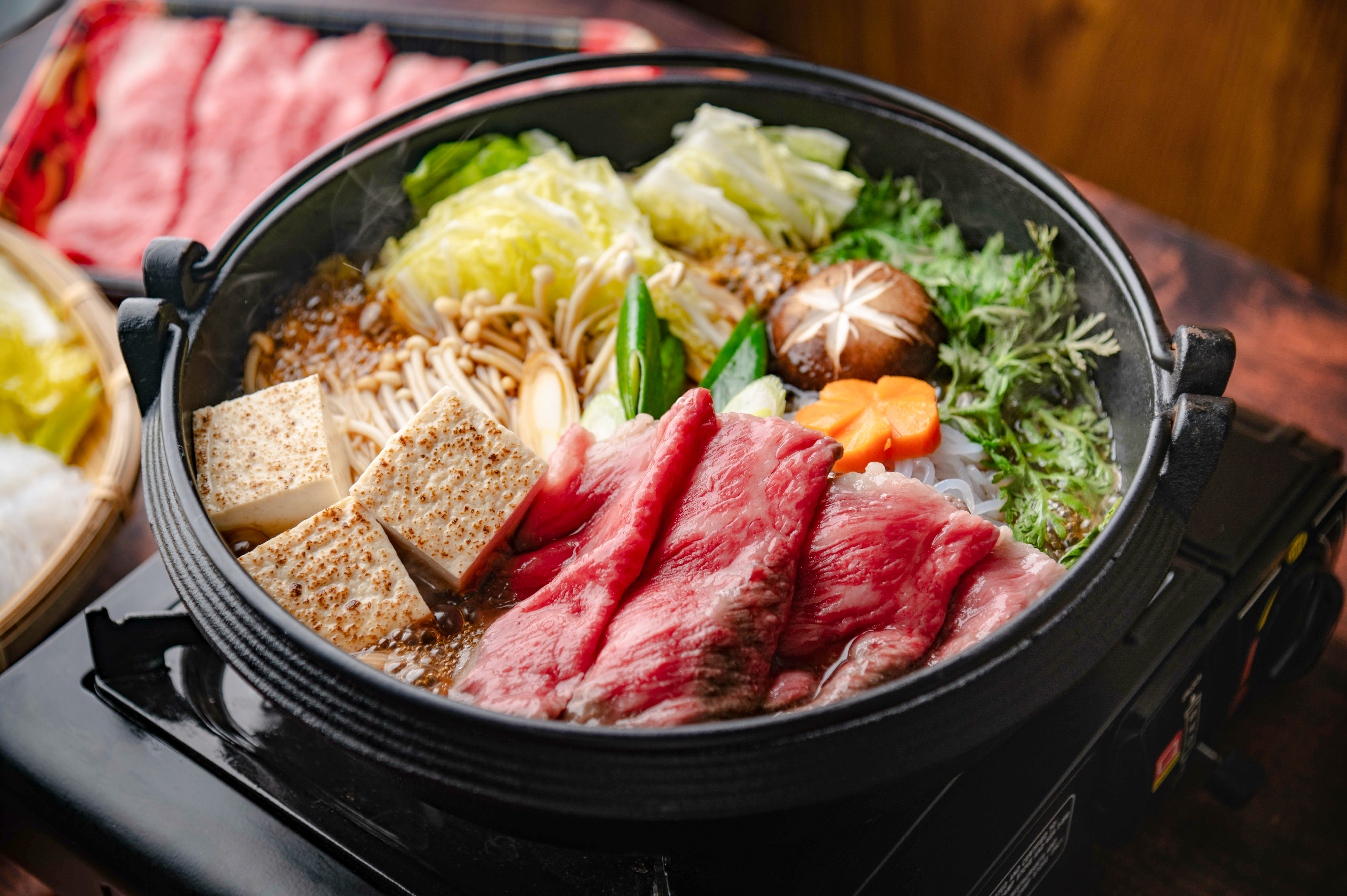 Wagyu shabu-shabu hot pot with fresh vegetables and dipping sauces in Tokyo, Japan.