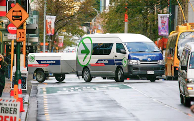 Super Shuttle van on city street for airport transfers.