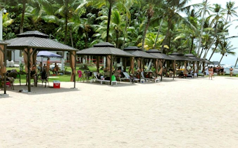Beach cabanas on Isla Mamey with palm trees and ocean view, Panama City tour.