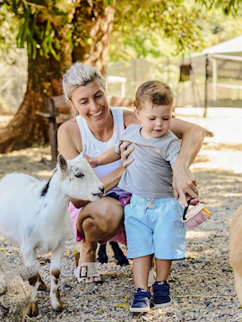 Child and adult interacting with goats at Sunshine Coast farm.