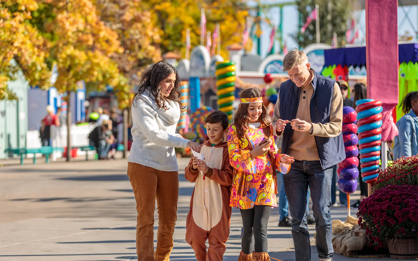 Family enjoying Oktoberfest at Canada's Wonderland, Six Flags, with colorful decorations and autumn trees.