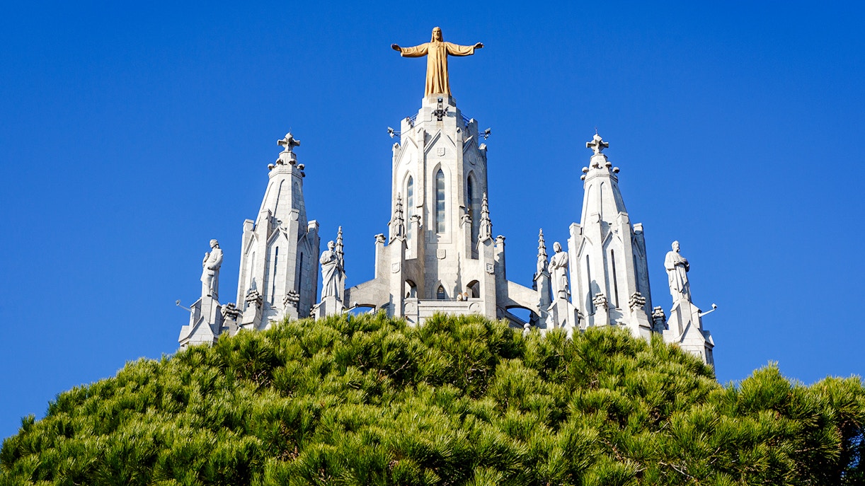 Temple of the Sacred Heart of Jesus, Barcelona, with statues and blue sky.