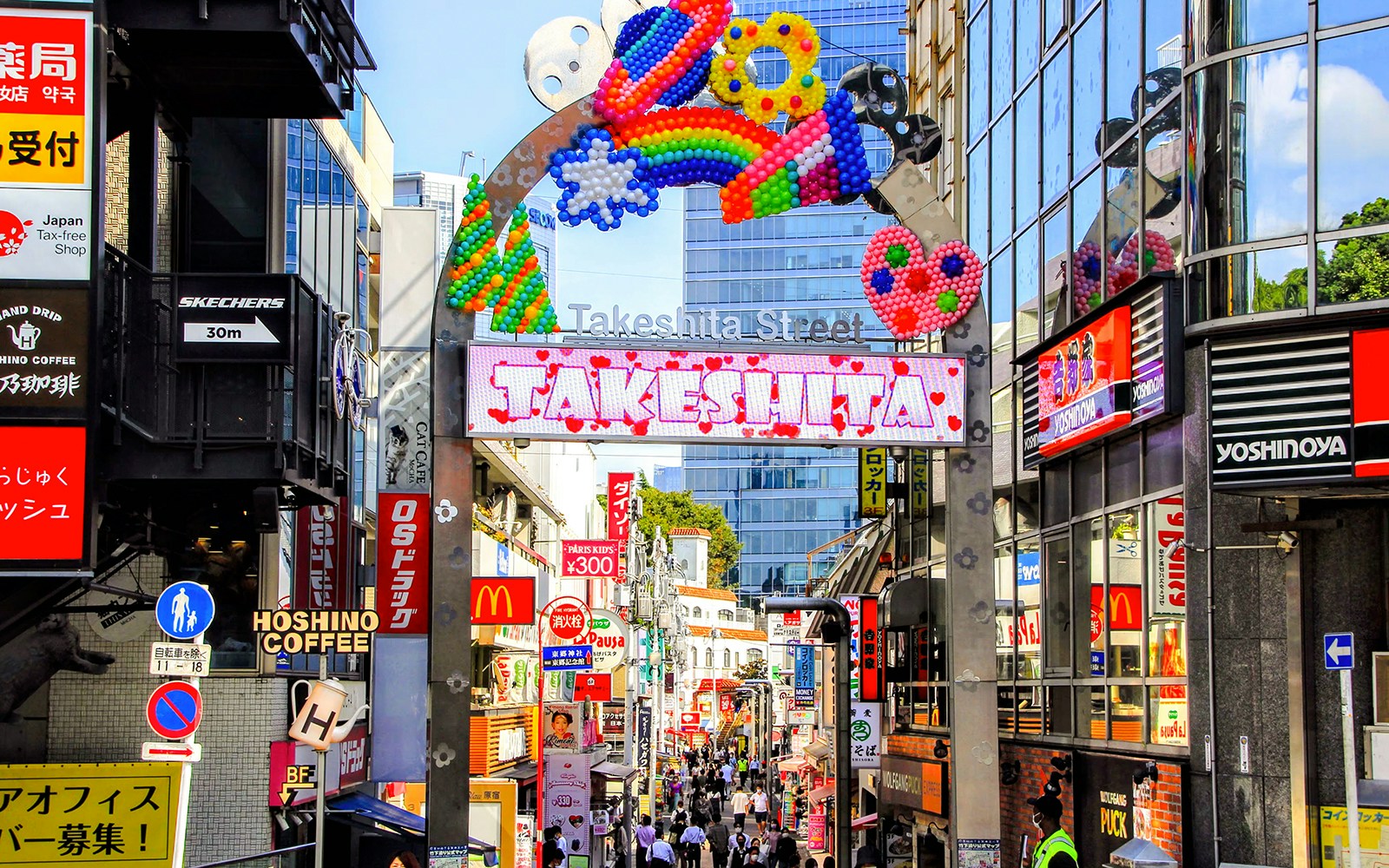 Takeshita Street entrance in Harajuku, Tokyo, bustling with shops and colorful decorations.