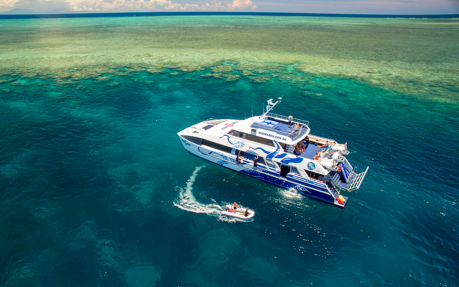 Catamaran on Outer Great Barrier Reef tour from Cairns with passengers enjoying the view.