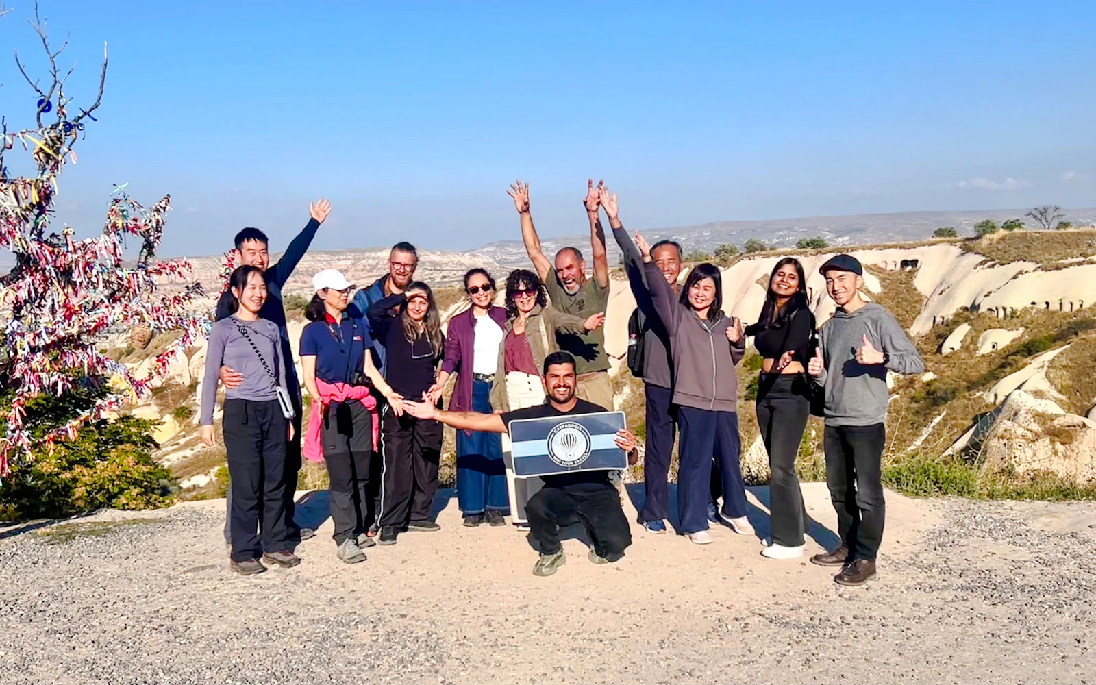 Group of tourists enjoying the Cappadocia Red Tour with scenic rock formations in the background.