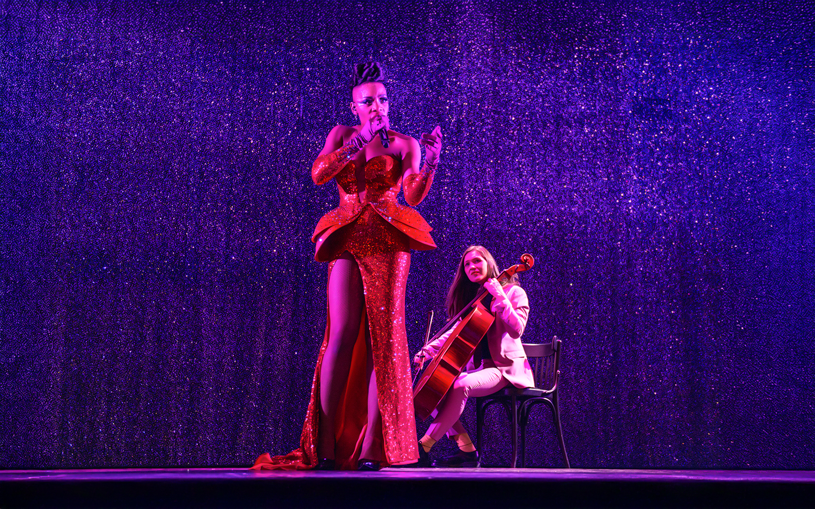 Singer on stage at Paradis Latin, Paris, performing in vibrant cabaret setting.