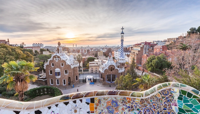 Palau Guell facade in Barcelona with intricate ironwork and stone arches.