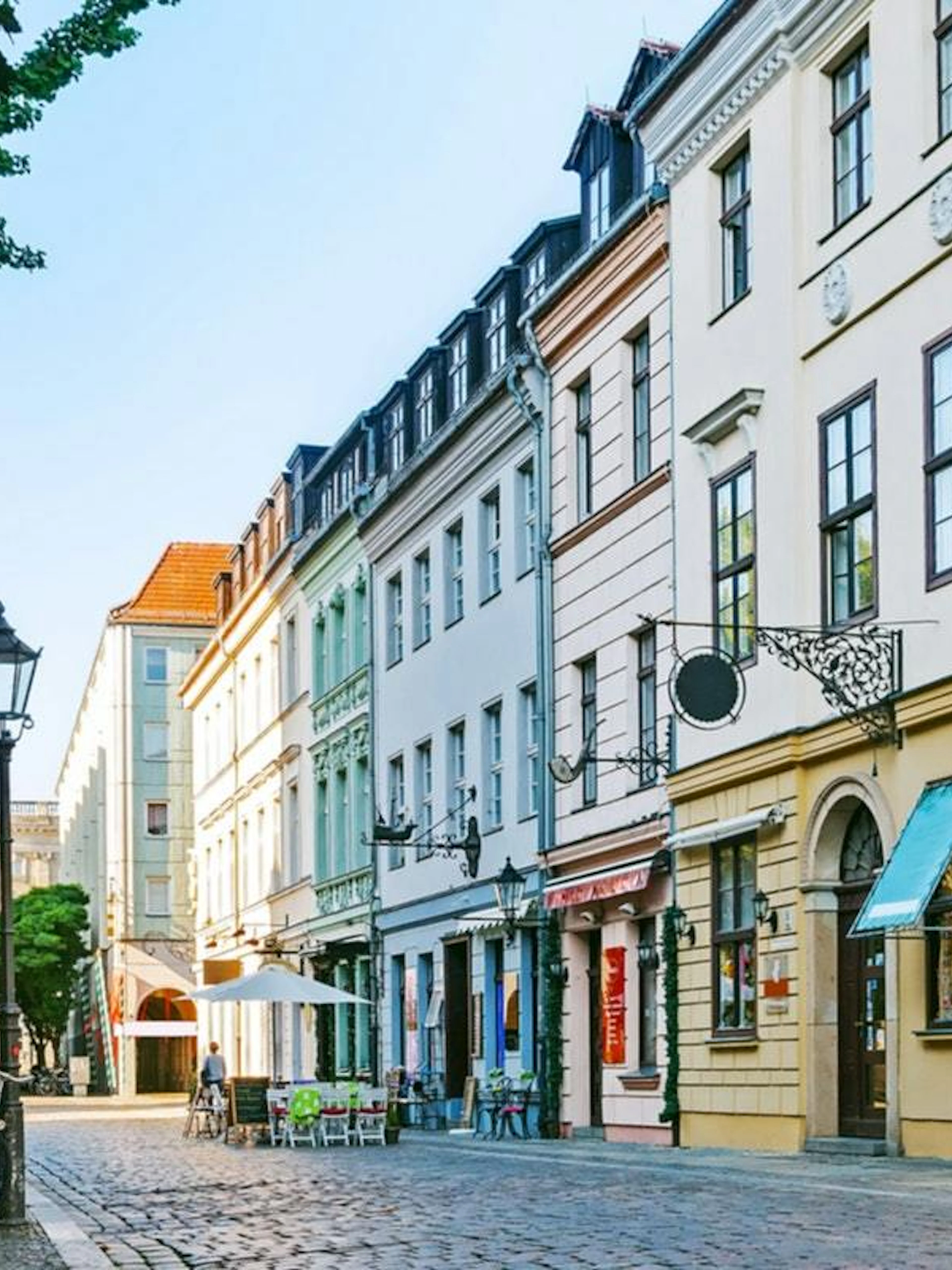 Cobblestone street with historic buildings in Berlin, part of the self-guided city exploration game.