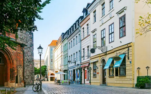 Cobblestone street with historic buildings in Berlin, part of the self-guided city exploration game.
