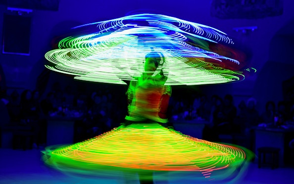 Tanoura dancer spinning with colorful lights on a cruise.