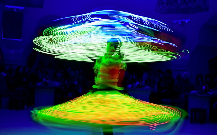 Tanoura dancer spinning with colorful lights on a cruise.
