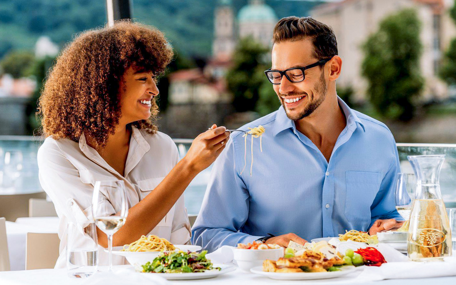 Couple enjoying lunch on Vltava River sightseeing cruise in Prague.