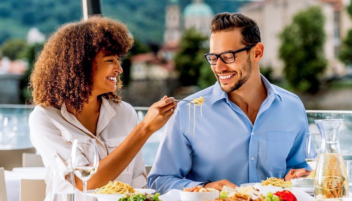 Couple enjoying lunch on Vltava River sightseeing cruise in Prague.