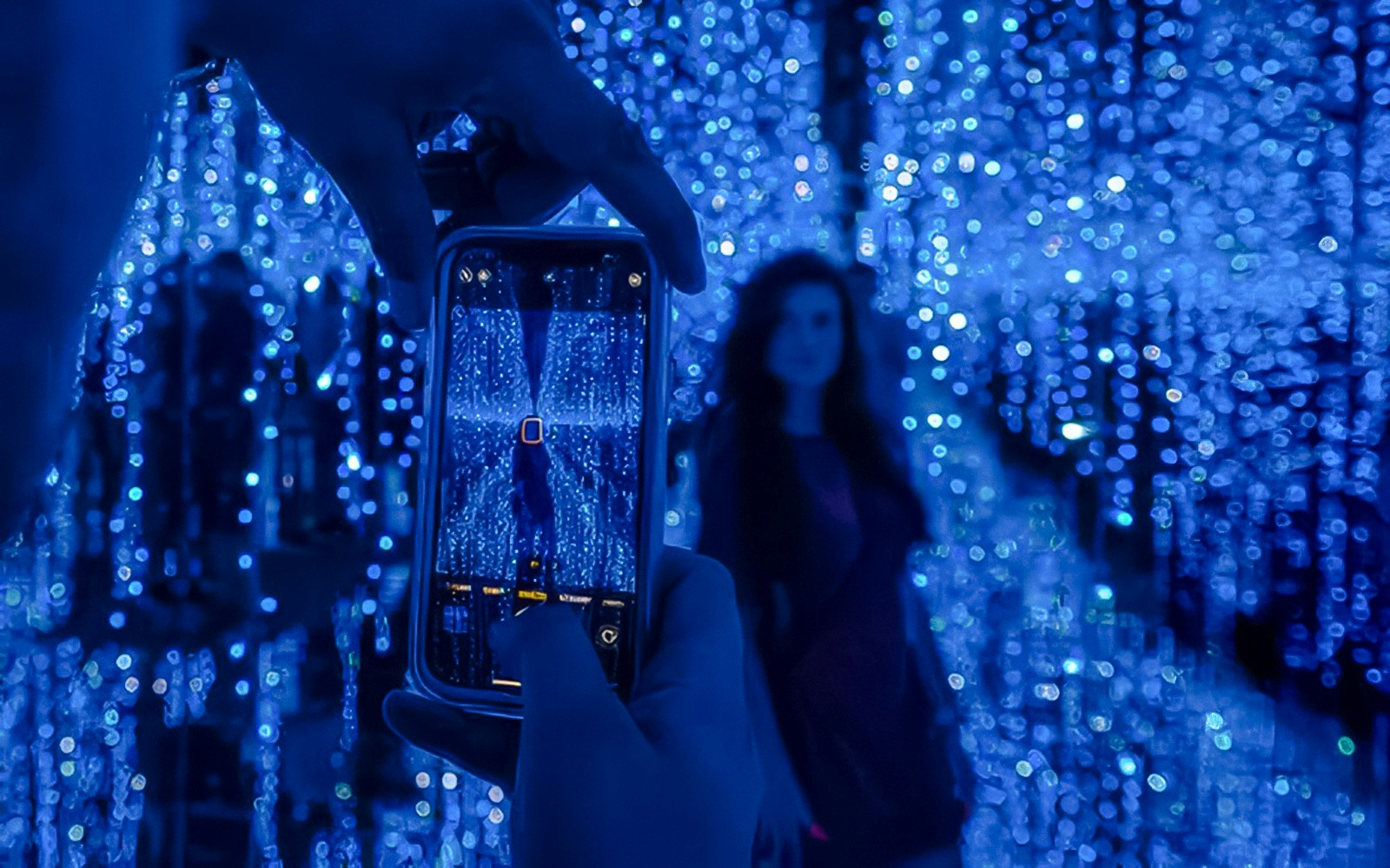 Visitor photographing the Star Room's blue light display at DeJa Vu Museum Berlin.