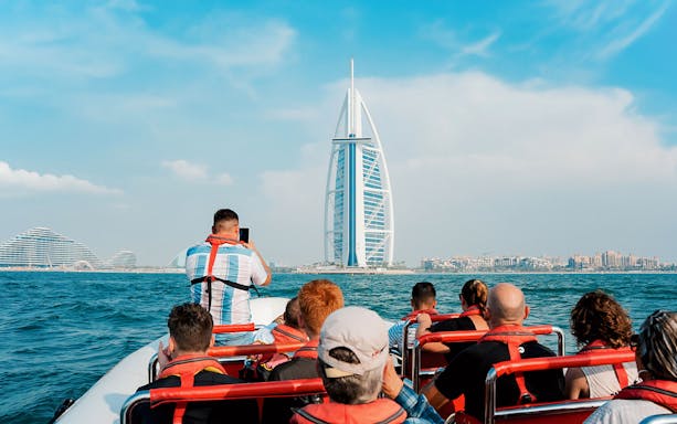 Speedboat tour group viewing Burj Al Arab from Dubai Marina.