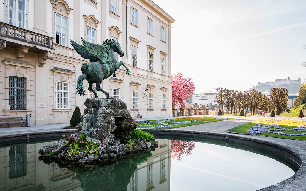 Pegasus statue in Mirabell Palace gardens, Salzburg, with Hohensalzburg Fortress in the background.