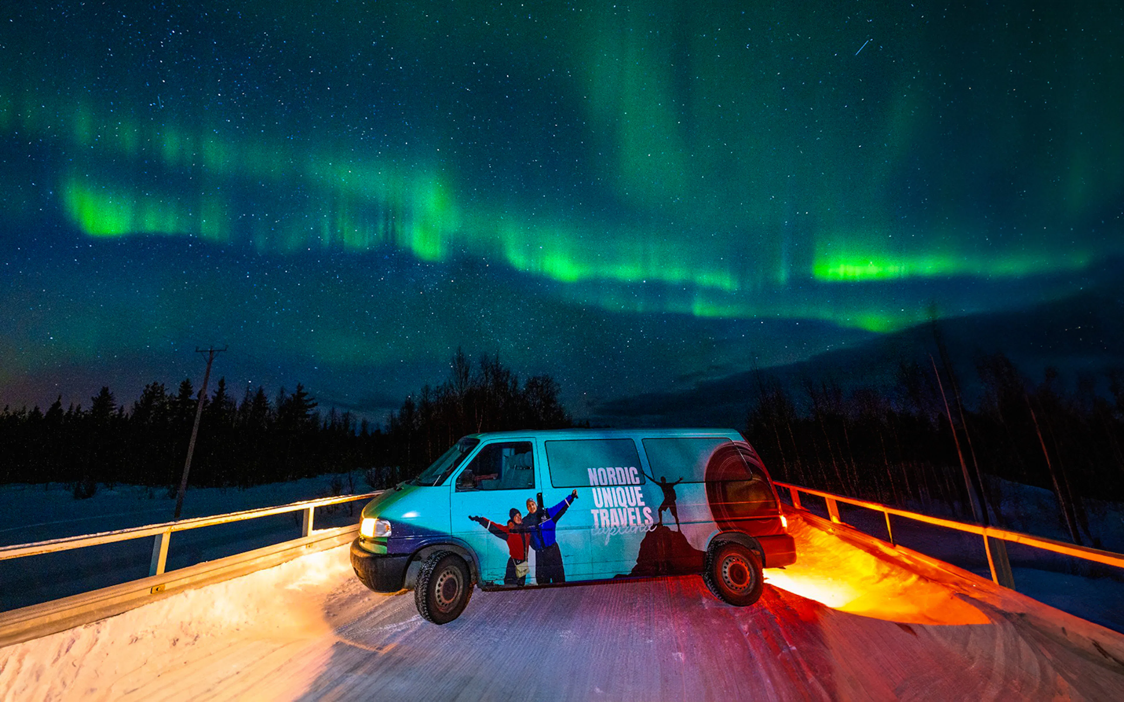 Van under Northern Lights on photography tour with hotel transfers.