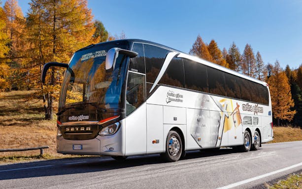 Cortina Express bus on route from Venice Marco Polo Airport to Cortina d'Ampezzo in autumn scenery.