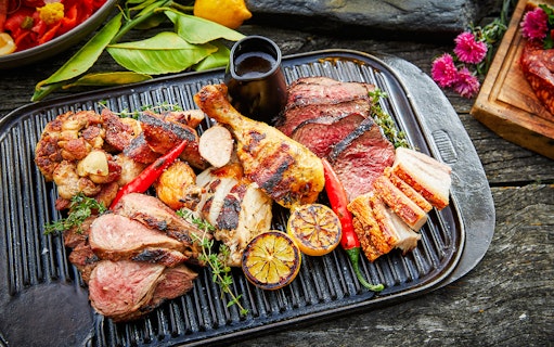 Grilled meats and vegetables on a platter at Walter Peak Gourmet BBQ Experience.