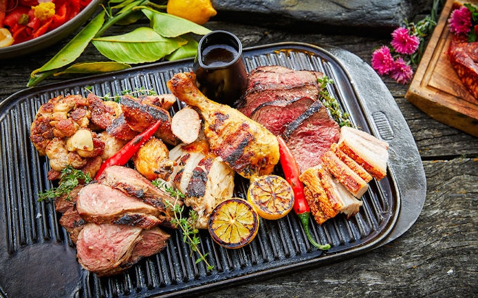 Grilled meats and vegetables on a platter at Walter Peak Gourmet BBQ Experience.