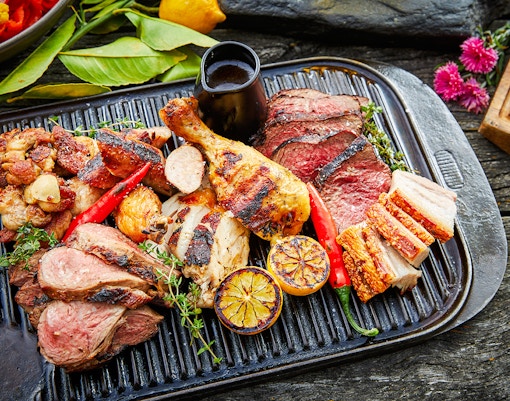 Grilled meats and vegetables on a platter at Walter Peak Gourmet BBQ Experience.